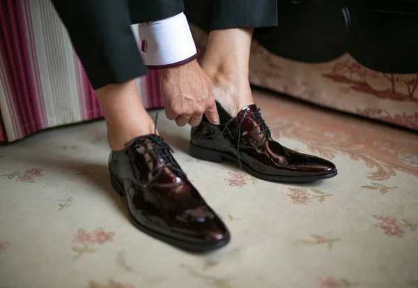 Hombre ponindose unos zapatos de Traje