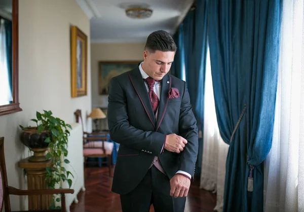 Hombre a just ndose un traje en un un hall