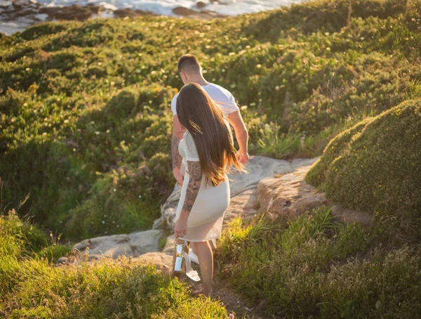 Joven pareja disfrutando de su amor en una puesta de sol frante al mar