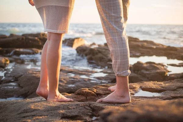 Joven pareja disfrutan de su amor frante una puesta sol en el mar