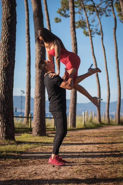 Joven pareja disfrutando de un paseo en una puesta de sol frante al mar