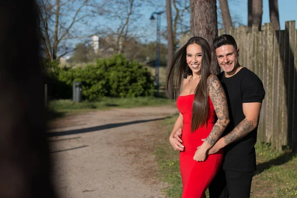 Joven pareja disfrutando de un paseo en una puesta de sol frante al mar
