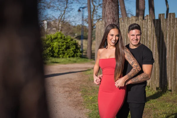 Joven pareja disfrutando de un paseo en una puesta de sol frante al mar