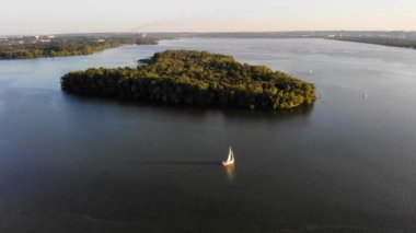 Nehir adası yakınlarında beyaz yelkenli yatı