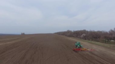 Hava manzaralı. Traktör ve ekiciler tarlada çalışıyor.