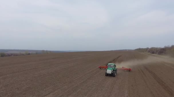 Traktor és kultivátor dolgozik a területen tavasszal. légi felvétel — Stock videók