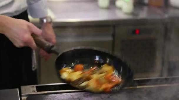 Chef jette les légumes frits dans une poêle — Video