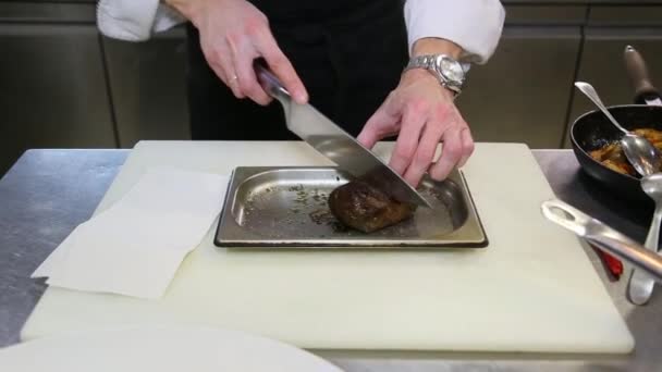 Ο σεφ κόβει τηγανητό κρέας με μαχαίρι Royalty Free Πλάνα Αρχείου