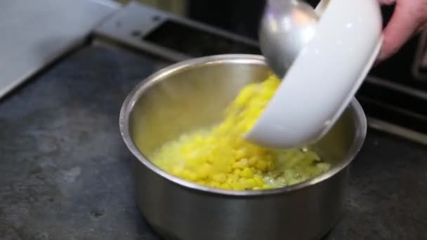 O cozinheiro coloca o milho em uma panela de metal — Vídeo de Stock
