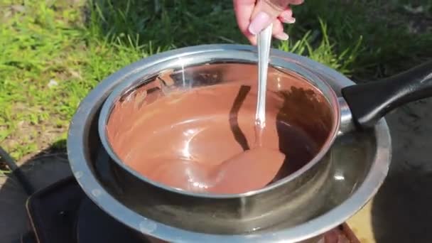 Το κορίτσι ανακατεύει ένα κουτάλι ζεστή σοκολάτα σε μια κατσαρόλα — Αρχείο Βίντεο