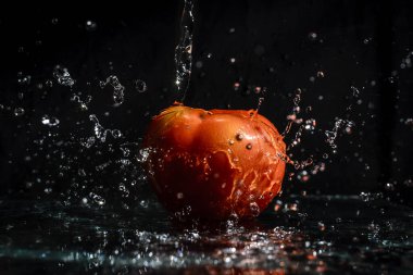 Agua caindo em to mate fresko com fundo preto.