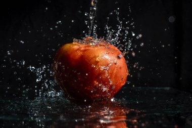 Agua caindo em to mate fresko com fundo preto.