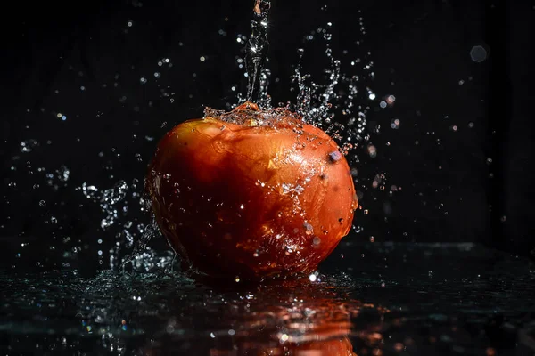 Agua caindo em to mate fresko com fundo preto.