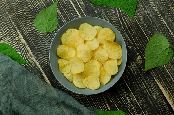 Collection of potato chips, beer snacks on dark background.
