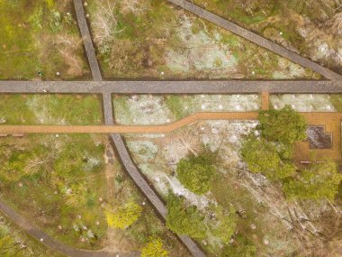 Baharın başında parktaki yeşil çimlerin üzerinde kar. Hava aracı görünümü.