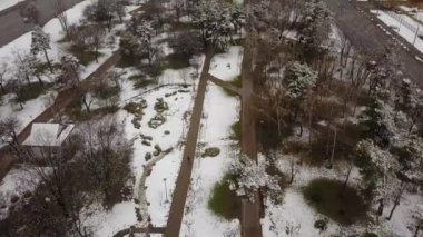 Baharın başında parkın üzerinde uçuyor, karla korunuyor. Patika boyunca uçuyor. Hava aracı görüntüleri..