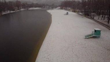 Karlı nehir kıyısında uçan kuşların hava manzarası