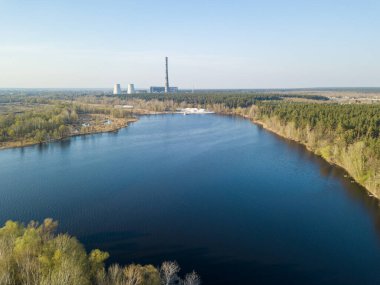 Bir şehrin eteklerindeki kozalaklı bir ormanda bir göl. Havadan