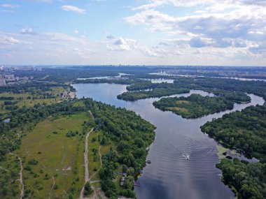 Kiev 'deki Dinyeper Nehri manzarası. Nehrin kıyısında yeşil ağaçlar. Güneşli bir bahar günü. Hava aracı görünümü