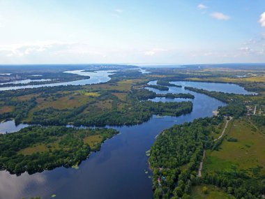 Kiev 'deki Dinyeper Nehri manzarası. Nehrin kıyısında yeşil ağaçlar. Güneşli bir bahar günü. Hava aracı görünümü