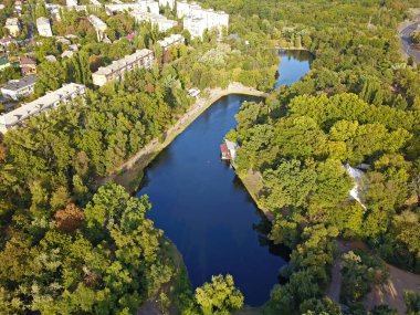 Şehrin dışındaki yaprak döken ormanlarda bir göl. Hava aracı görünümü