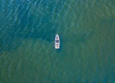 Kiev 'deki Dinyeper Nehri' nde bir motorlu tekne yüzüyor. Nehrin kıyısında yeşil ağaçlar. Güneşli bahar günü.