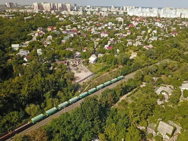 Aerial view. Freight train rides through the forest