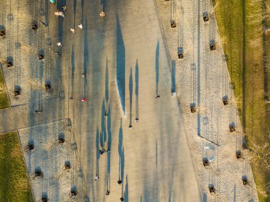 Hava görüntüsü. Yoldan geçenlerin gölgeleri sonbahar sabahı meydanda