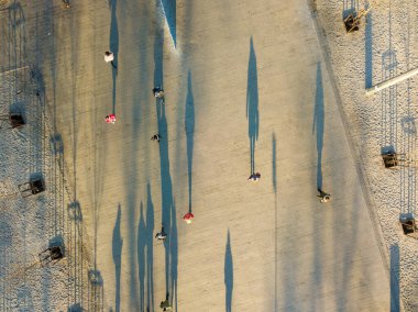 Hava görüntüsü. Yoldan geçenlerin gölgeleri sonbahar sabahı meydanda