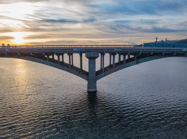 Hava görüntüsü. Metro köprüsü şafakta. Kyiv metrosu köprüden geçiyor