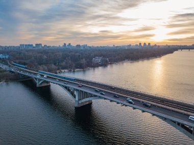 Hava görüntüsü. Metro köprüsü şafakta. Kyiv metrosu köprüden geçiyor