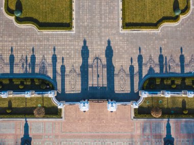 Hava aracı görüntüsü. Parktaki çitten kaldırıma gölgeler