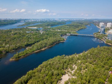 Kiev 'deki Dinyeper Nehri manzarası. Nehrin kıyısında yeşil ağaçlar. Güneşli bir bahar günü. Hava aracı görünümü.