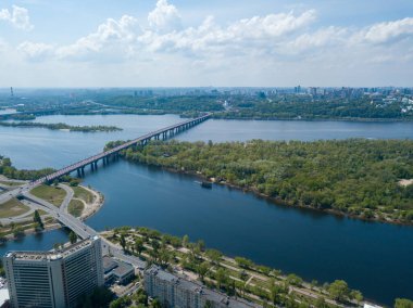 Kiev 'deki Dinyeper Nehri manzarası. Nehrin kıyısında yeşil ağaçlar. Güneşli bir bahar günü. Hava aracı görünümü.