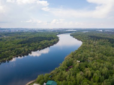 Kiev 'deki Dinyeper Nehri manzarası. Nehrin kıyısında yeşil ağaçlar. Güneşli bir bahar günü. Hava aracı görünümü.