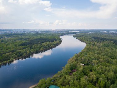 Kiev 'deki Dinyeper Nehri manzarası. Nehrin kıyısında yeşil ağaçlar. Güneşli bir bahar günü. Hava aracı görünümü.