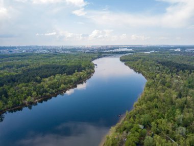 Kiev 'deki Dinyeper Nehri manzarası. Nehrin kıyısında yeşil ağaçlar. Güneşli bir bahar günü. Hava aracı görünümü.