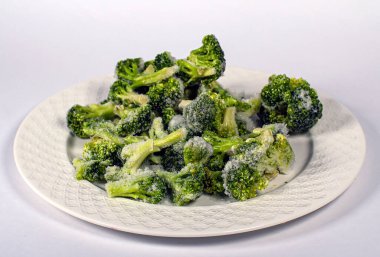   Beyaz bir tabakta donmuş brokoli.