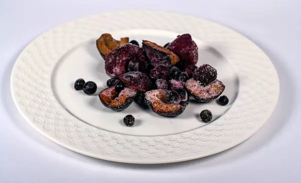 Donmuş meyveler beyaz bir tabakta