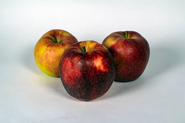 Beyaz arkaplanda üç elma