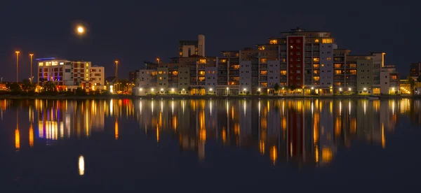 The moon and cityscape lights, reflect off harbour waters, poole — Stock Photo, Image