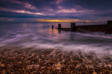 Milford-on-Sea 'de gün batımında Groyne' lerin uzun süre görülmesi