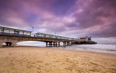 Bournemouth İskelesi üzerindeki renkli gökyüzü suya yansıyor.