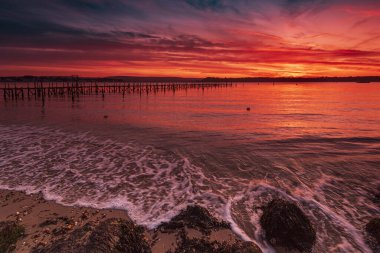 Turuncu ve kırmızı gökyüzü Sandbanks yakınındaki bir Poole Harbour iskele üzerinde derin renkler