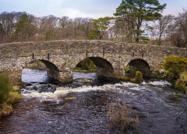 1780 'lerde inşa edilen 13. yüzyıldan kalma bir Clapper Köprüsü ve yakınlardaki 2. derece köprü, Posta Köprüsü' nün merkezini işaret ediyor.