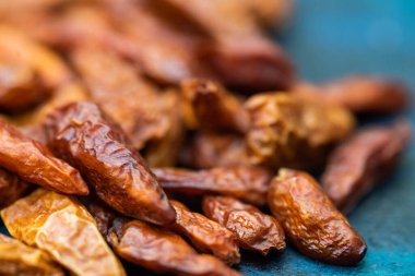 Koyu mavi arka planda yemeğe baharat eklemek için kurutulmuş kırmızı biber.