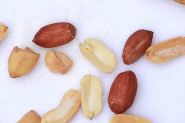 Beyaz arkaplanda tuz bulunan üst görünüm ham fıstıklar, seçici odak