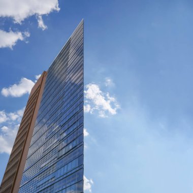 Mavi gökyüzü ve bulutlu cam bina