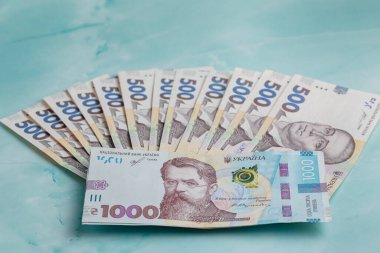 1000 hryvnias bir deste paranın yanında dokuma turkuaz arka planda yatıyor 500 hryvnias