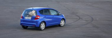 KIEV, UKRAINE-JULY 4.2017: Mavi araba Honda Jazz güneşli gökyüzünün arka planına karşı yolda park etti. Otomotiv fotoğrafçılığı. Mesaj için yer var. Arabalı arkaplan. 